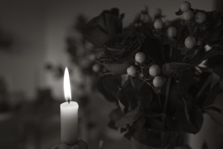 Bougie et fleurs blanches évoquant un médaillon funéraire en porcelaine